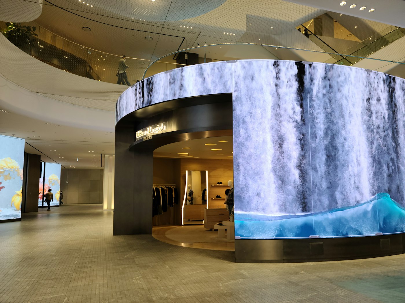 Pantalla LED curva en el acceso de una tienda dentro de un centro comercial